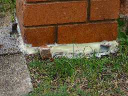 Base of repaired brick fence post.